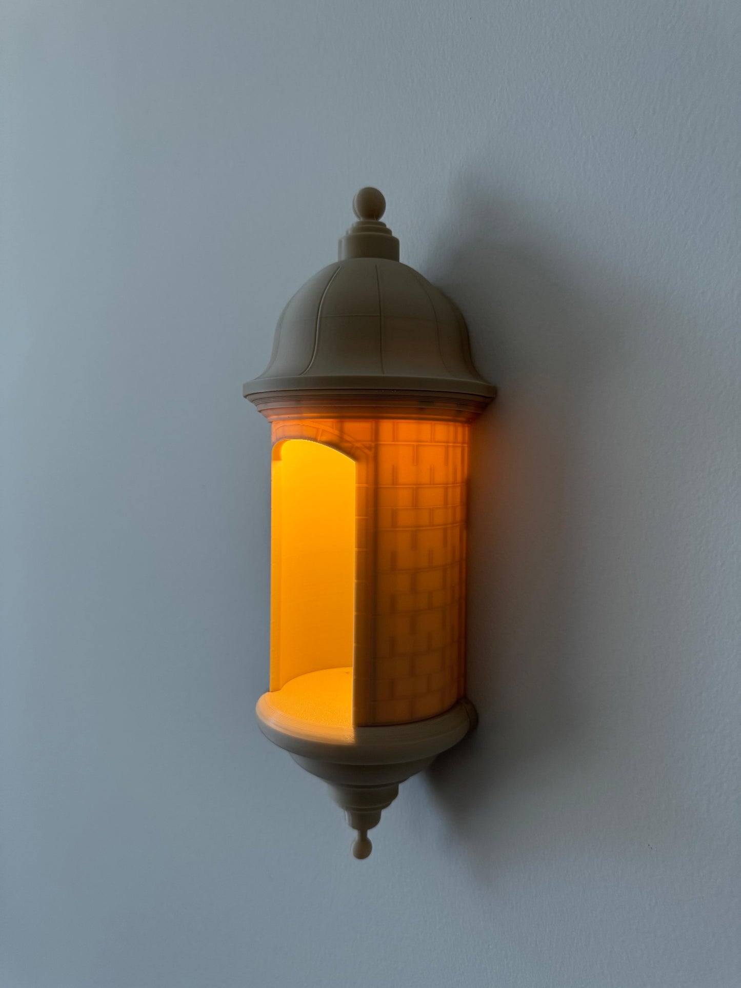 Decorative wall light fixture with warm glow on a plain wall