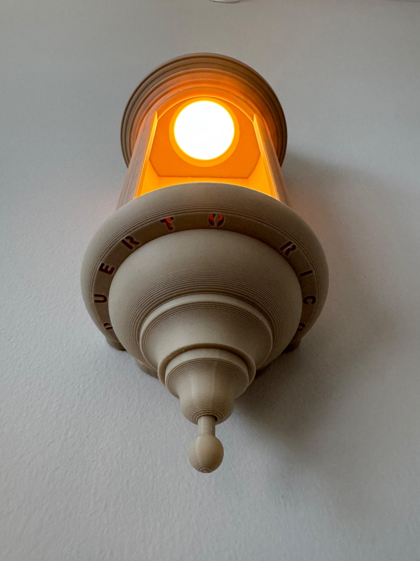 Decorative wall light fixture with a warm glow on a plain wall.