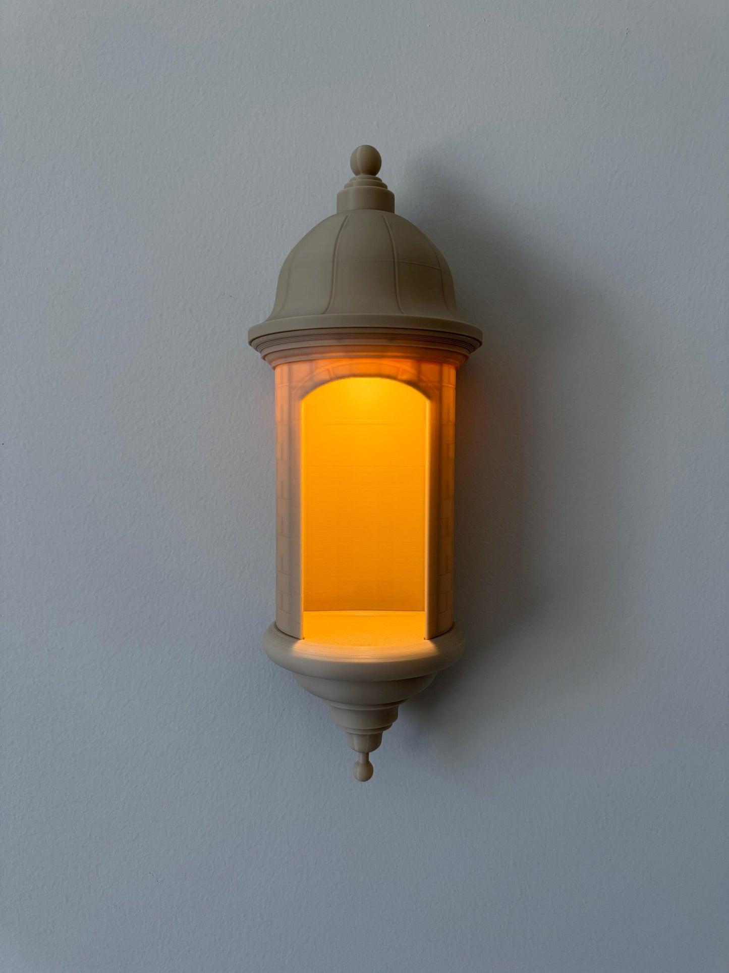 Decorative wall light fixture with warm glow on a plain wall