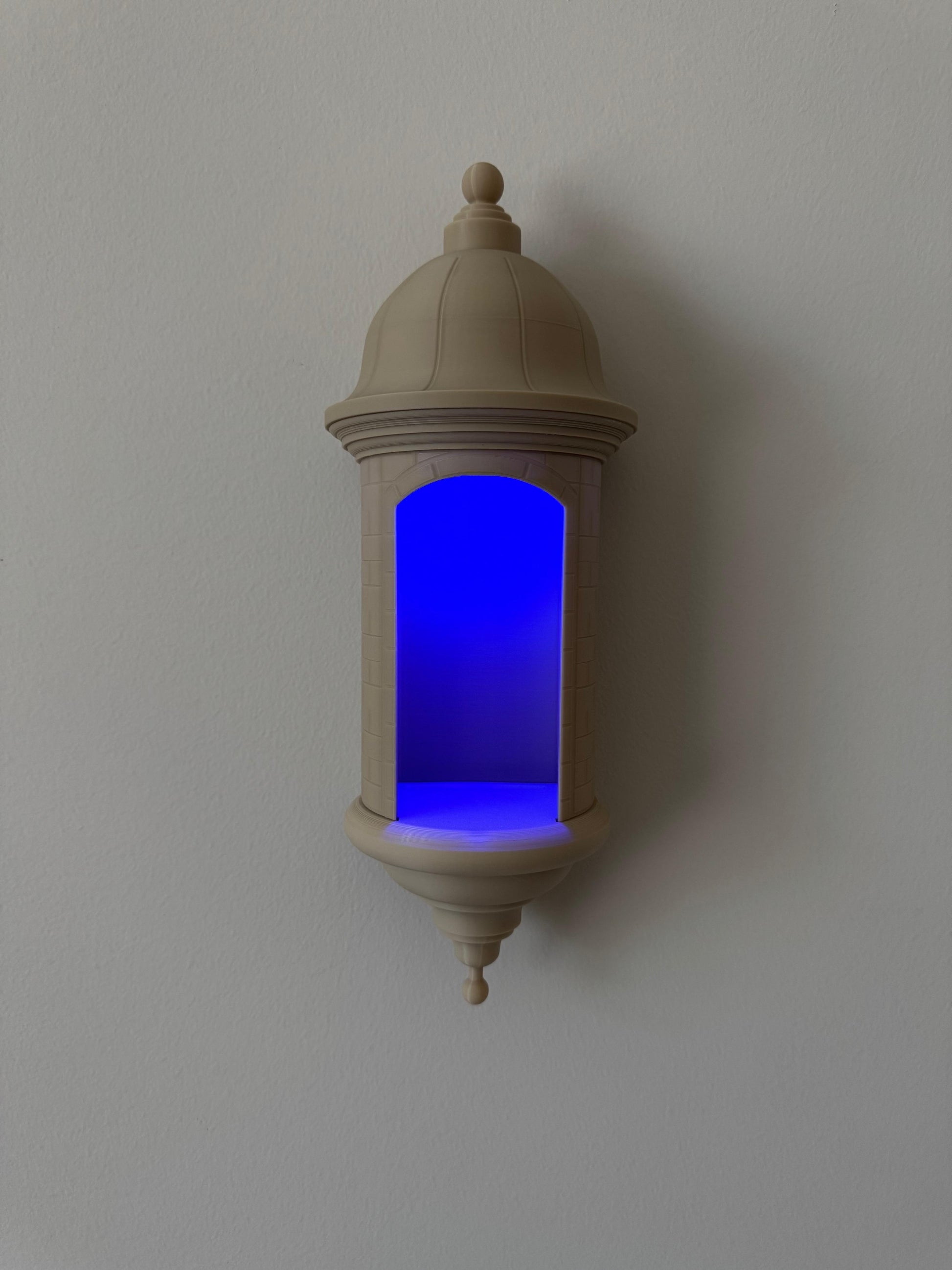 Decorative wall sconce with a blue light on a plain wall